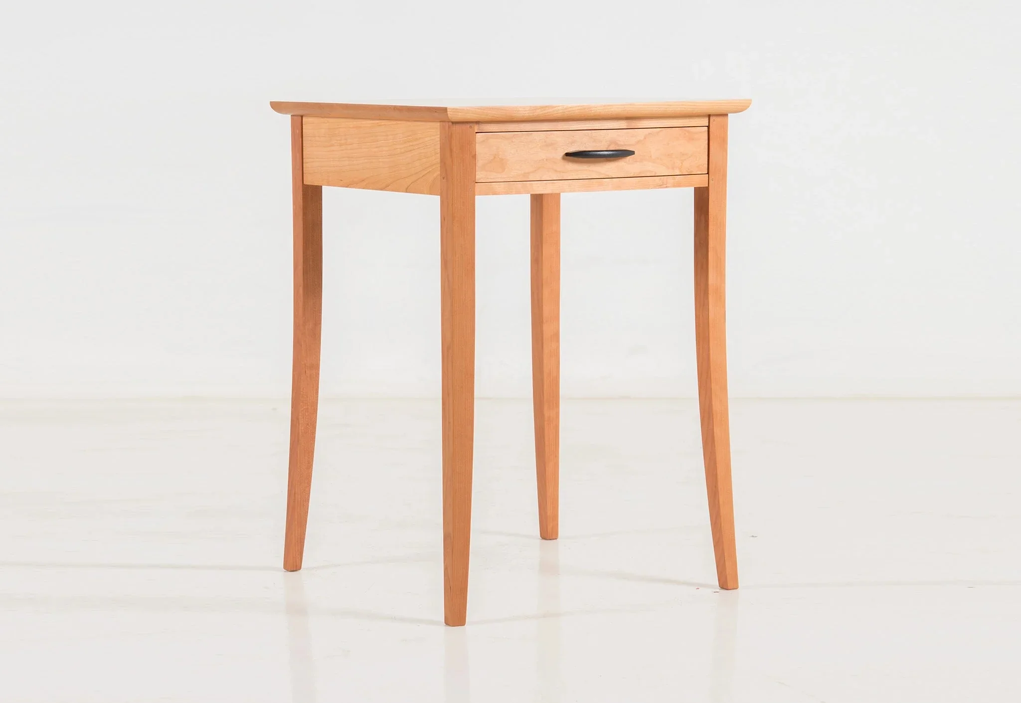 End Table - The embraces simplicity, marked by four hand-tooled legs that flow to a gentle curve as they ease to the